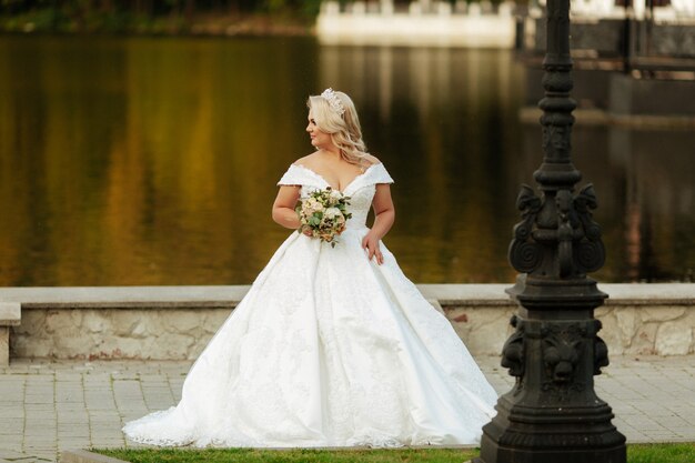 Mooie bruid met een boeket van verschillende bloemen op het meer. Rustieke bruiloft