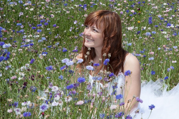 Mooie bruid met rood haar met blauwe bloemen