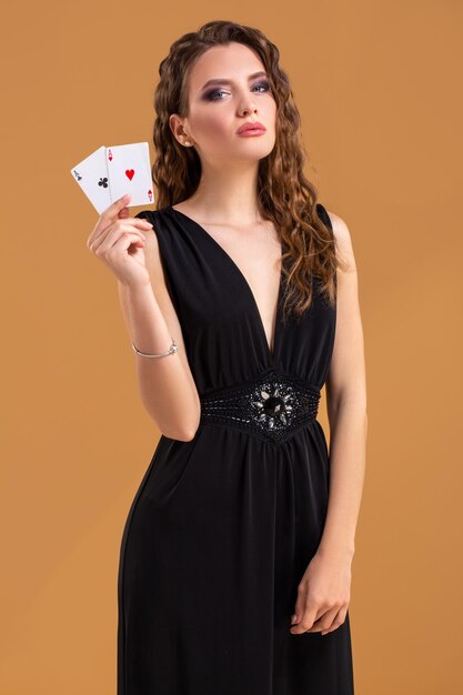 Mooie bruinharige vrouw met twee azen als teken voor pokerspel, gokken en casino