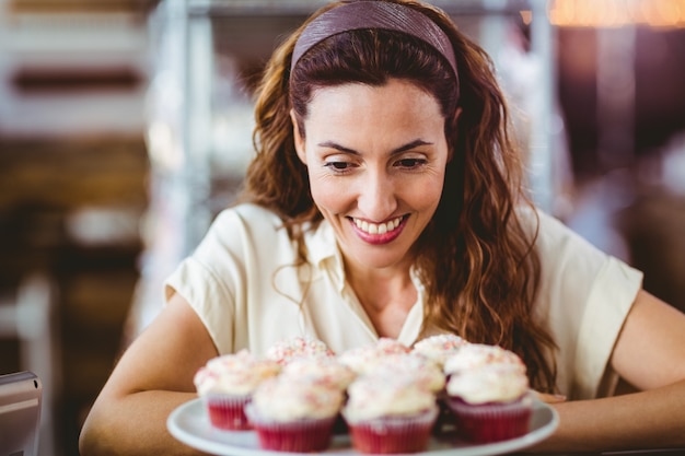 Mooie brunette die cakes bekijkt