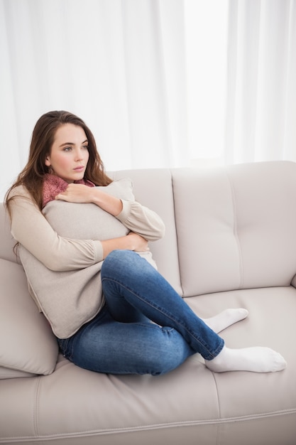 Mooie brunette die een kussen koestert