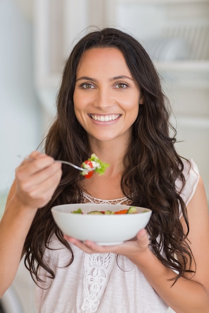 Mooie brunette die een salade eet