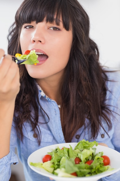 Mooie brunette die een salade voor lunch eet