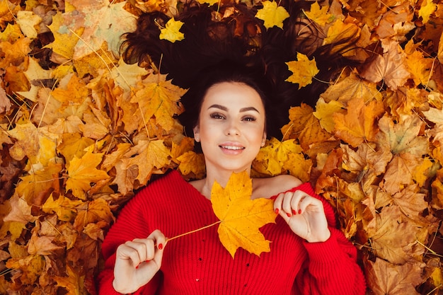 Mooie brunette in de herfst bos met een fiets