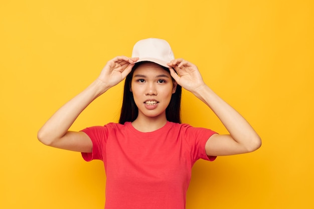 Foto mooie brunette in een rood t-shirt met een pet op haar hoofd