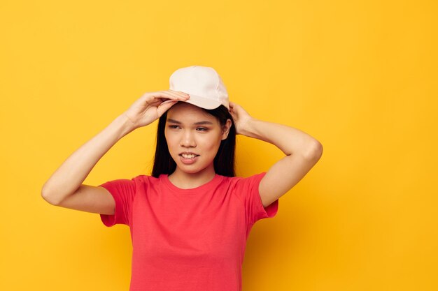 Mooie brunette in een rood t-shirt met een pet op haar hoofd