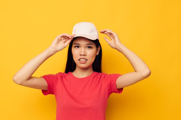 Mooie brunette in een rood t-shirt met een pet op haar hoofd