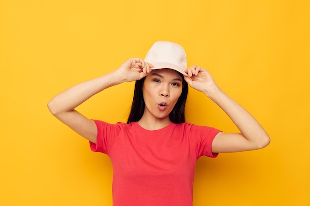 Mooie brunette in een rood t-shirt met een pet op haar hoofd