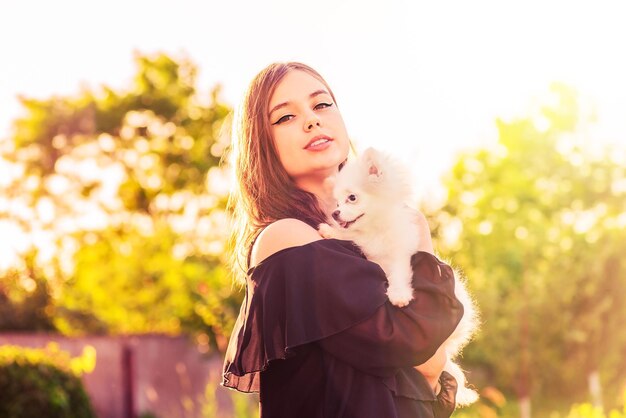 Mooie brunette meid met haar hond in haar armen Een tienermeisje en een spitspuppy