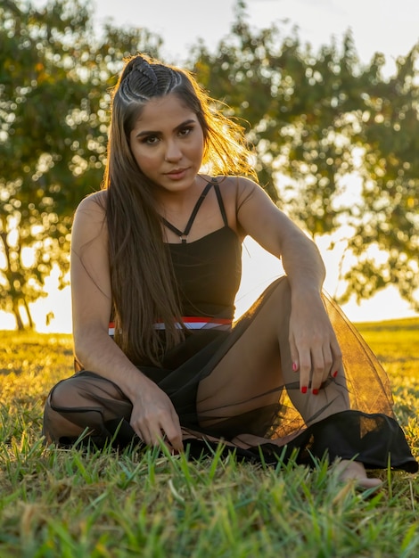 Mooie brunette meisje poseren op foto's in de natuur bij zonsondergang.