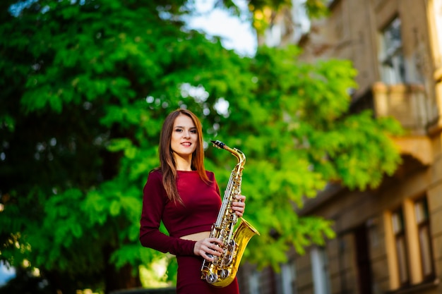 Mooie brunette speelt de saxofoon in het park