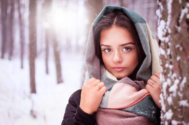 Mooie brunette staat in een winterbos