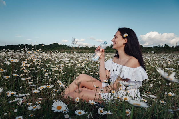 Mooie brunette vrouw geniet van de lente in een veld met madeliefjes