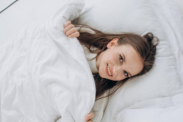 Mooie brunette vrouw in bed close-up