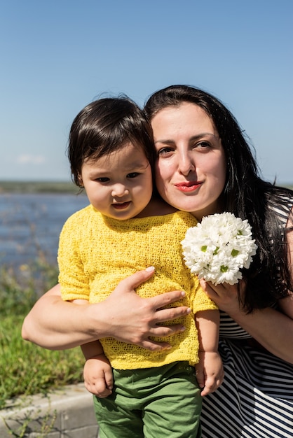 Mooie brunette vrouw in een gestreepte jurk met haar kind