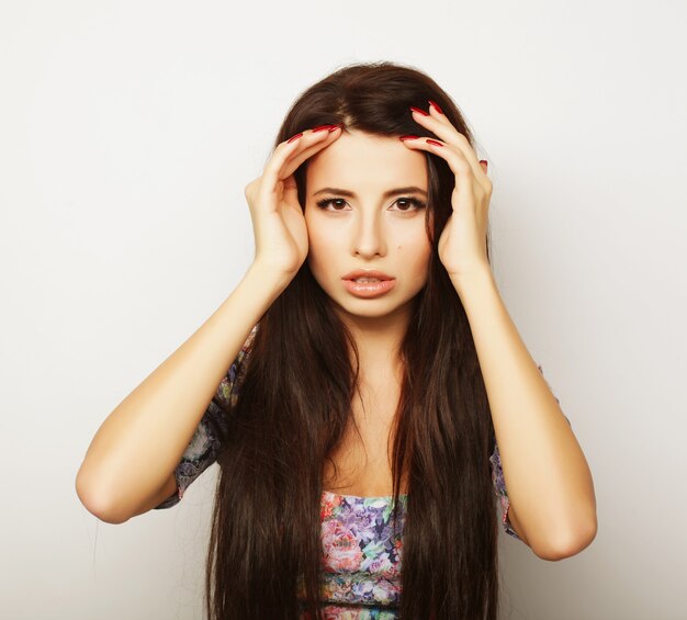 Mooie brunette vrouw in zomerjurk op witte achtergrond