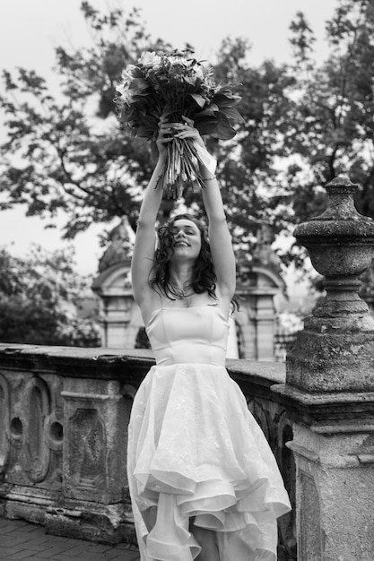 Mooie brunette vrouw met een boeket bloemen in een roze jurk