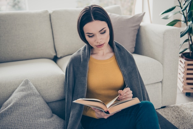 Mooie brunette vrouw poseren binnenshuis met een boek