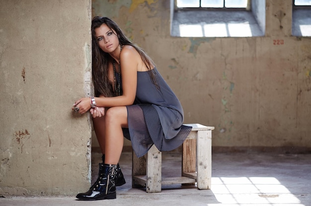 Mooie brunette vrouw zittend op een stoel en poseren op camera.