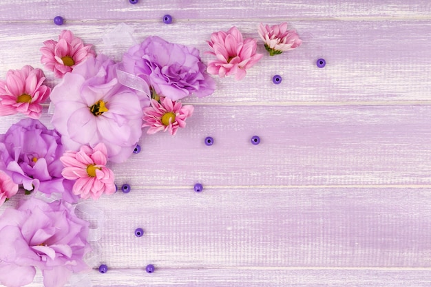Mooie chrysant en kunstmatige eustoma bloemen op paarse houten achtergrond