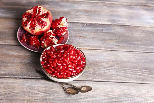 Foto mooie compositie met sappige granaatappelpitjes op oude houten tafel