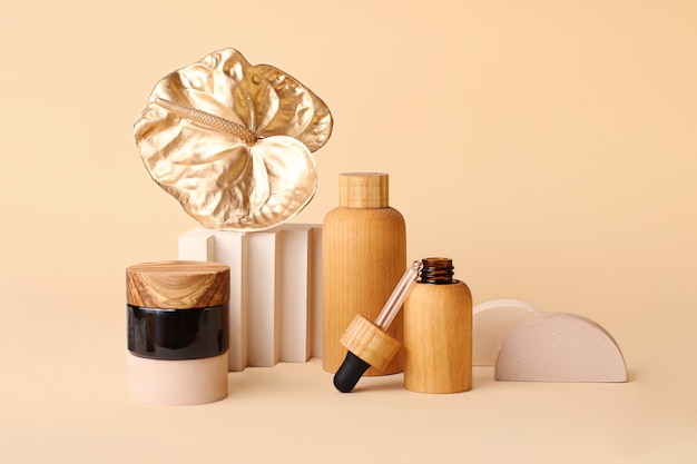 Mooie compositie van de cosmeticaflessen en gouden flamingobloem