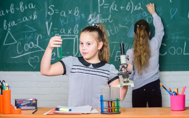 Mooie dag in het laboratorium Kleine wetenschapper werkt met microscoop Biologieles Scheikundeonderzoek wetenschapsexperimenten in biologielaboratorium Kleine meisjes in schoollabbiologieonderwijs