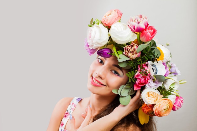 Mooie dame met bloeiende bloemen op haar hoofd. Natuurbloemblaadje Kapsel en make-up