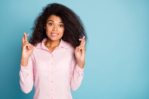 mooie dame met gekruiste vingers te wachten lip bijten