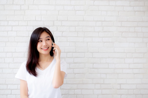 Mooie de besprekings slimme telefoon en glimlach van de portret aziatische vrouw