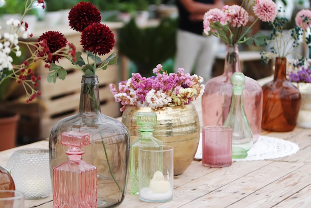 Mooie decoratie met bloemen en kleurrijke glazen vazen