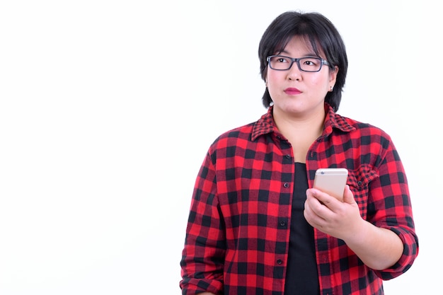 mooie dikke Aziatische hipster vrouw met kort haar brillen geïsoleerd tegen een witte muur dragen