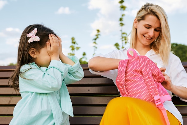 Mooie dochter bedekt haar ogen terwijl haar moeder een verrassing maakt buiten Gelukkige moederdag Cheefrul jonge vrouw glimlachend en spelend met haar kind in het park Familievakantie en saamhorigheid