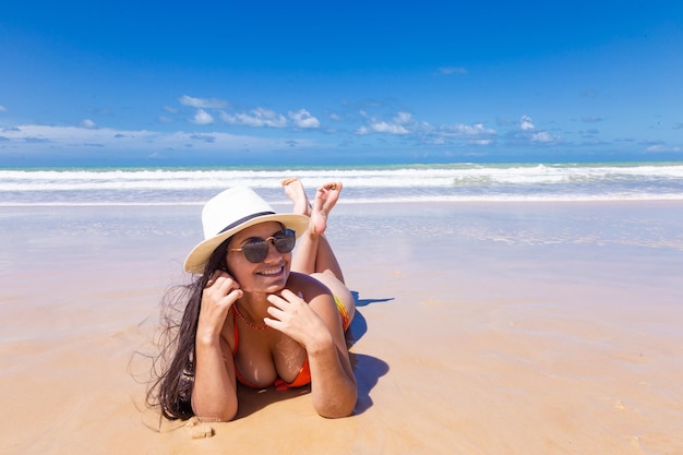 Mooie donkerbruine vrouw op het strand met exemplaarruimte