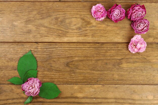 Mooie droge bloemen en bladeren op houten achtergrond