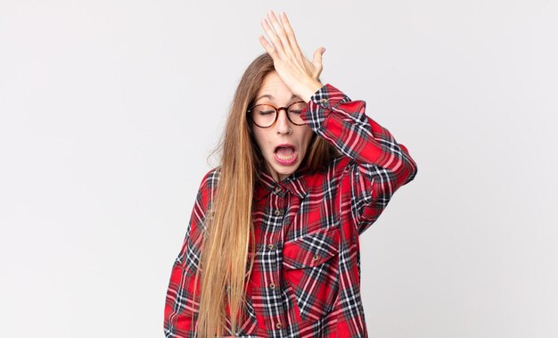 Mooie dunne vrouw die handpalm naar voorhoofd steekt en denkt oeps, na een stomme fout te hebben gemaakt of zich te herinneren, voelde ze zich dom