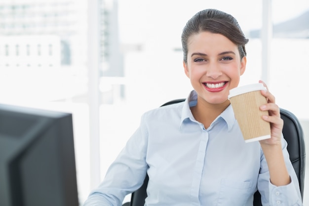 Mooie elegante bruine haired onderneemster die van koffie geniet