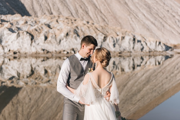 Mooie elegante paar pasgetrouwden verliefd op een prachtige natuurlijke natuur zout bergen en steengroeven