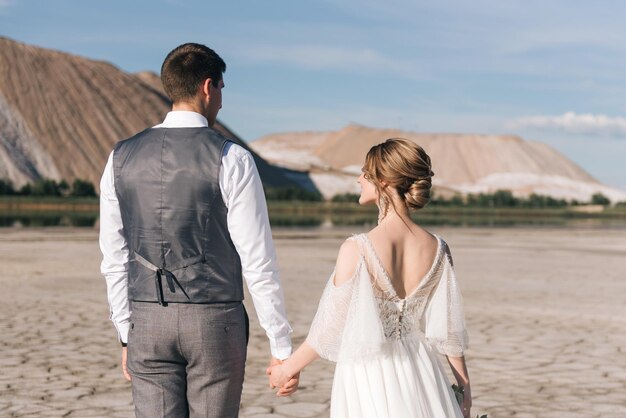 Mooie elegante verliefde pasgetrouwden op een prachtige natuurlijke achtergrond van zoutbergen en steengroeven