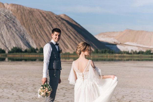 Mooie elegante verliefde pasgetrouwden op een prachtige natuurlijke achtergrond van zoutbergen en steengroeven