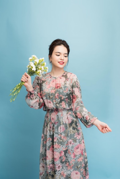 Mooie elegante vrouw die bloemenjurk draagt