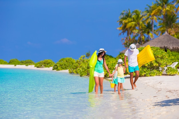 Mooie en gelukkige familie op wit strand met luchtbedden