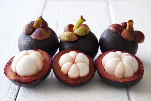 Mooie en heerlijke drie gepelde mangostans en drie mangostans gezet