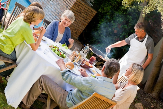 Foto mooie familie die in de tuin eet