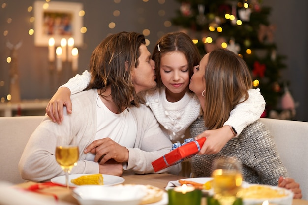 Mooie familie met cadeautjes die cadeautjes delen tijdens het kerstdiner