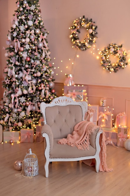 Mooie feestelijk ingerichte roze kamer met een kerstboom, geschenken. Nieuwjaar.