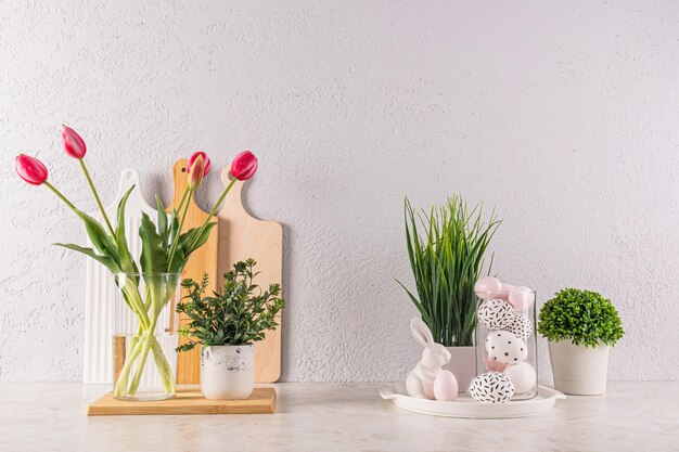 Mooie feestelijke decoratie van het aanrecht in de keuken voor Paasdag vaas met tulpgroene planten eieren met patroon in hoge glazen paashazen