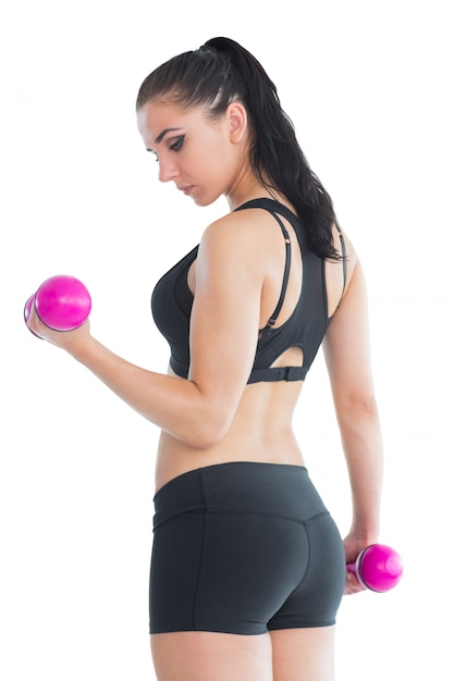 Mooie fit vrouw haar armen met roze halters trainen