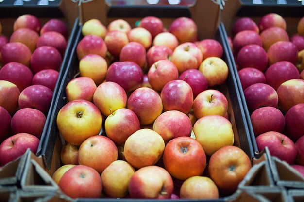 Mooie fruitachtergrond met rode appels in een kartonnen doos.