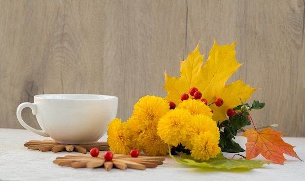 Mooie gele bloem, kopje op houten tafel. Herfststilleven met chrysantenbloem.